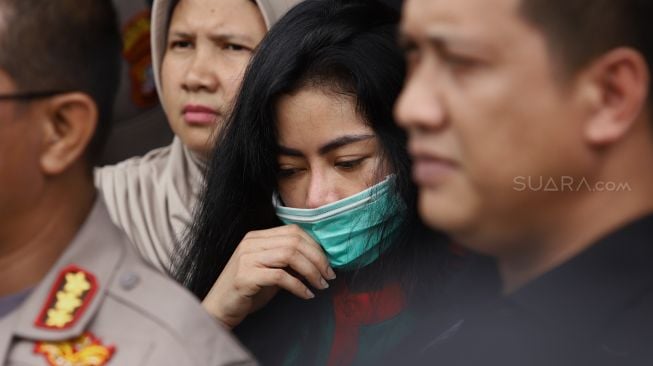 Vitalia Shesha memegang masker saat dihadirkan sebagai tersangka dalam gelar perkara kasus narkoba publik figur di Polres Metro Jakarta Barat, Kamis (27/2). [Suara.com/Angga Budhiyanto]