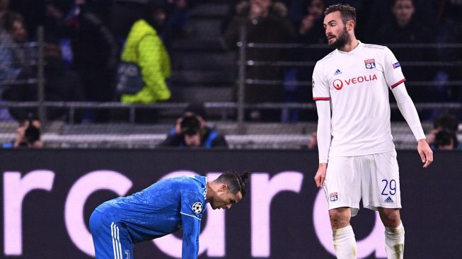 Pemain Juventus Cristiano Ronaldo tertunduk di sebelah gelandang Lyon asal Prancis Lucas Tousart selama putaran leg pertama babak 16 besar Liga Champions antara Lyon melawan Juventus di Stadion Parque Olympique Lyonnais, Perancis, Kamis (27/2) dini hari WIB.  [FRANCK FIFE / AFP]