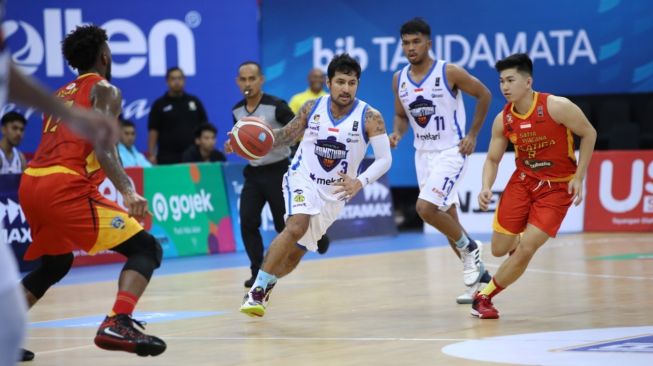 Pemain Amartha HangTuah, Kelly Purwanto mencoba melewati hadangan pemain Satya Wacana Salatiga dalam laga Seri V IBL 2020 di GOR Jayabaya, Kediri, Jawa Timur, Jumat (28/2/2020). [Dok. IBL]