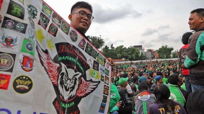 Bendera berisi atribut dari berbagai komunitas driver Ojol (Ojek Online) saat aksi unjuk rasa di depan Gedung DPR dan MPR RI, Jakarta, Jumat (28/02). [Suara.com/Alfian Winanto]