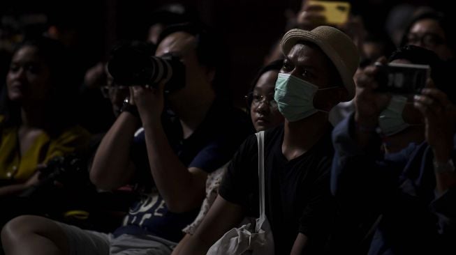 Penonton Java Jazz Festival 2020 menggunakan masker di Jakarta, Jumat (28/2).  [ANTARA FOTO/Muhammad Adimaja]