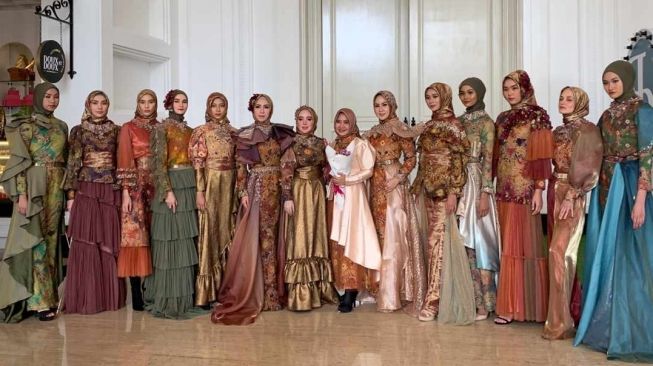 Riris Ghofir bersama 13 model yang mengenakan rancangannya. [dokumentasi pribadi]