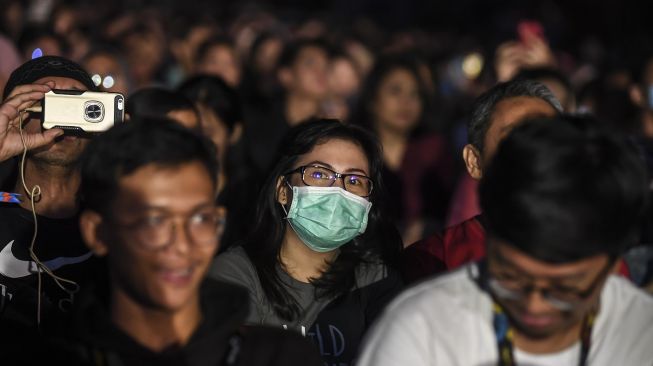 Penonton Java Jazz Festival 2020 menggunakan masker di Jakarta, Jumat (28/2).  [ANTARA FOTO/Muhammad Adimaja]