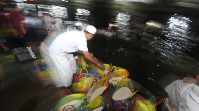 Sejumlah relawan haul KH Muhammad Zaini Abdul Ghani (Abah Guru Sekumpul) bergotong royong membersihkan beras di Irigasi Sekumpul, Martapura, Kalimantan Selatan, Sabtu (29/2) malam.[ANTARA FOTO/Bayu Pratama S] 