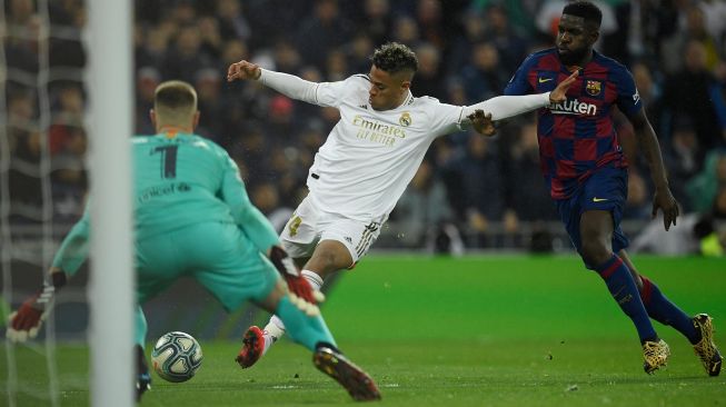 Pemain depan Real Madrid Mariano Diaz (kiri) mencetak gol kedua timnya selama pertandingan sepak bola Liga Spanyol antara Real Madrid melawan Barcelona di Stadion Santiago Bernabeu, Madrid, Spanyol, Senin (2/3) dini hari WIB. [OSCAR DEL POZO / AFP]