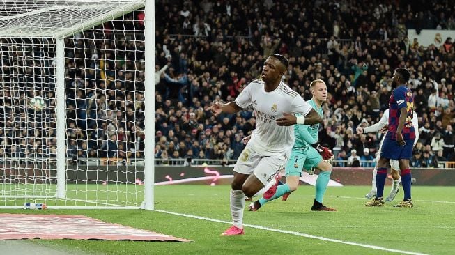 Pemain depan Real Madrid Vinicius Junior mencetak gol selama pertandingan sepak bola Liga Spanyol antara Real Madrid melawan Barcelona di Stadion Santiago Bernabeu, Madrid, Spanyol, Senin (2/3) dini hari WIB.  [OSCAR DEL POZO / AFP]