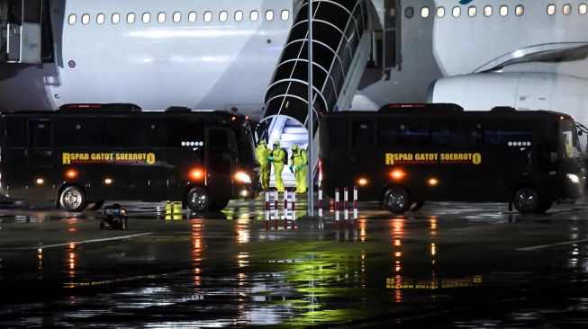 Petugas mengenakan pakaian pelindung lengkap saat bersiap menyambut kedatangan kru kapal pesiar Diamond Princess yang dinyatakan negatif virus corona di Bandara Kertajati, Kabupaten Majalengka, Jawa Barat, Minggu (1/3).  [ANTARA FOTO/Muhammad Adimaja]