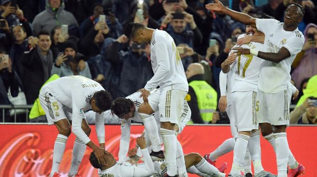 Para pemain Real Madrid memberi selamat kepada penyerang Mariano Diaz (BOTTOM) untuk golnya selama pertandingan sepak bola Liga Spanyol antara Real Madrid melawan Barcelona di Stadion Santiago Bernabeu, Madrid, Spanyol, Senin (2/3) dini hari WIB. [OSCAR DEL POZO / AFP]