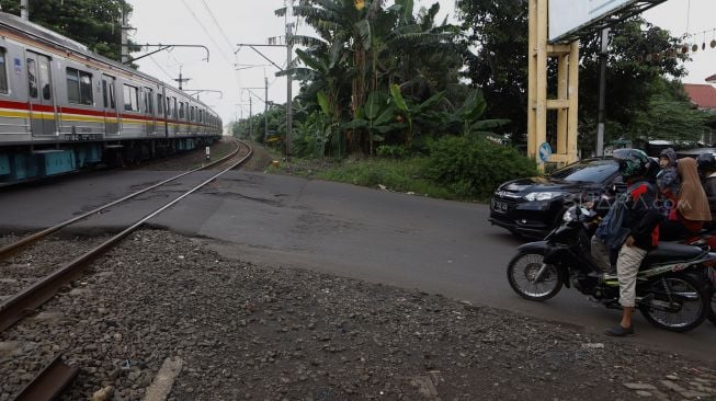 Kereta melintas di pelintasan kereta Bumi Bintaro Permai, Pesanggrahan, Jakarta Selatan, Senin (2/3).  [Suara.com/Angga Budhiyanto]