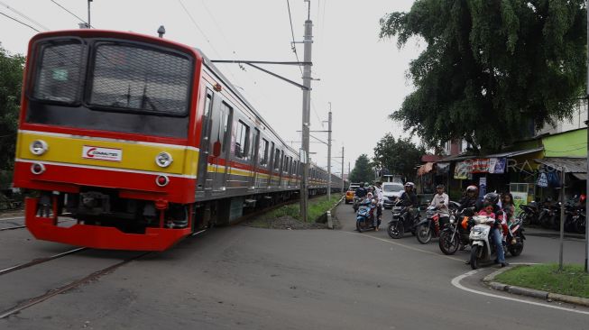 Sejumlah pengendara menunggu kereta melintas di pelintasan kereta Bumi Bintaro Permai, Pesanggrahan, Jakarta Selatan, Senin (2/3).  [Suara.com/Angga Budhiyanto]