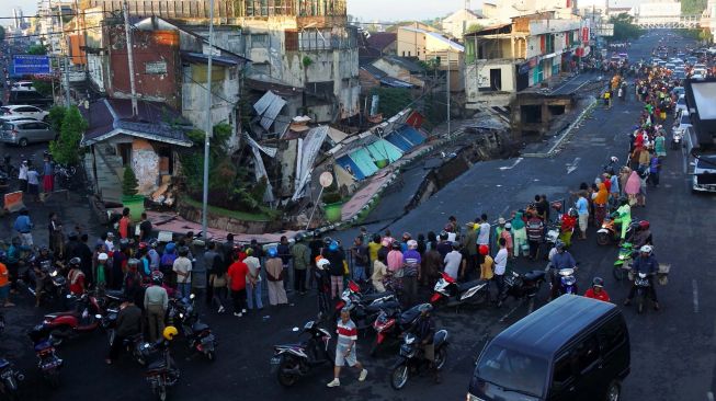 Warga melihat pertokoan Jompo yang ambruk di Jalan Sultan Agung Jember, Jawa Timur, Senin (2/3). [ANTARA FOTO/Seno]
