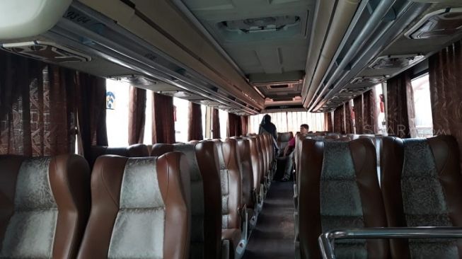 Penampakan aktivitas penumpang di dalam bus di Terminal Blok M, Jakarta Selatan. (Suara.com/Novian).