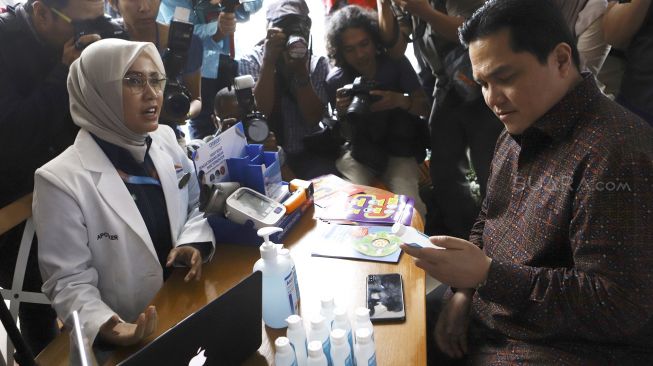 Dokter berbincang dengan Menteri BUMN Erick Thohir saat meninjau Apotek Kimia Farma, Menteng, Jakarta, Rabu (4/3).[Suara.com/Angga Budhiyanto]
