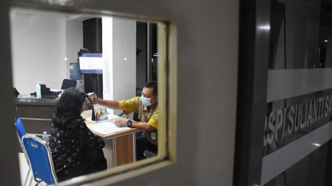 Dokter memeriksa suhu tubuh warga di Pos Pemantauan Virus Corona RSPI Sulianti Saroso, Jakarta Utara, Selasa (3/3).  [ANTARA FOTO/Indrianto Eko Suwarso]