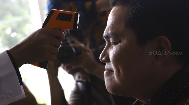 Tim dokter memeriksa suhu tubuh Menteri BUMN Erick Thohir saat meninjau Apotek Kimia Farma, Menteng, Jakarta, Rabu (4/3). [Suara.com/Angga Budhiyanto]