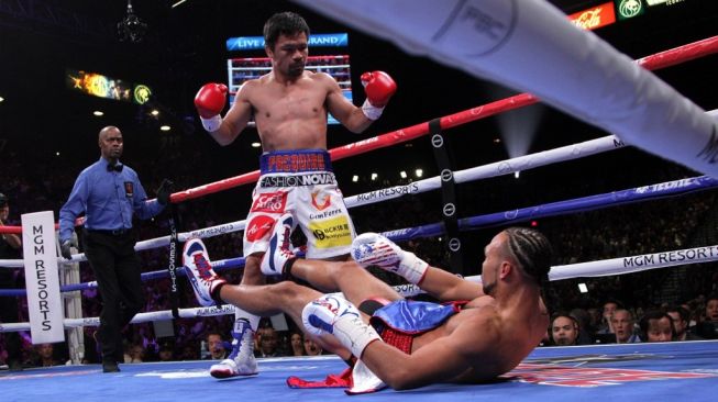 Petinju Filipina, Manny Pacquiao (tengah), menjatuhkan lawannya Keith Thurman dalam kejuaraan tinju dunia kelas welter WBA (Super) di MGM Grand Garden Arena, Las Vegas, Sabtu (20/7/2019). [AFP/John Gurzinkski]