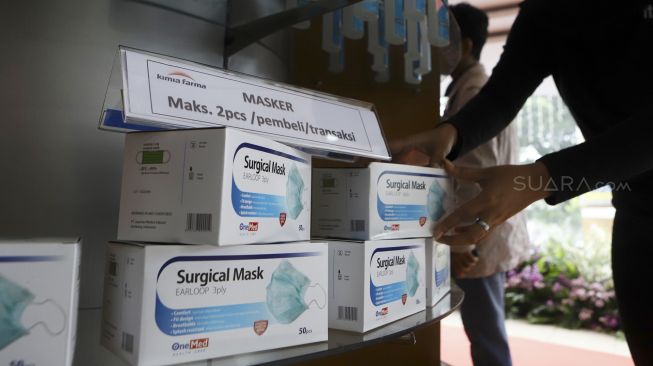 Petugas menata masker di apotek Kimia Farma Menteng, Jakarta, Rabu (4/3). [Suara.com/Angga Budhiyanto]