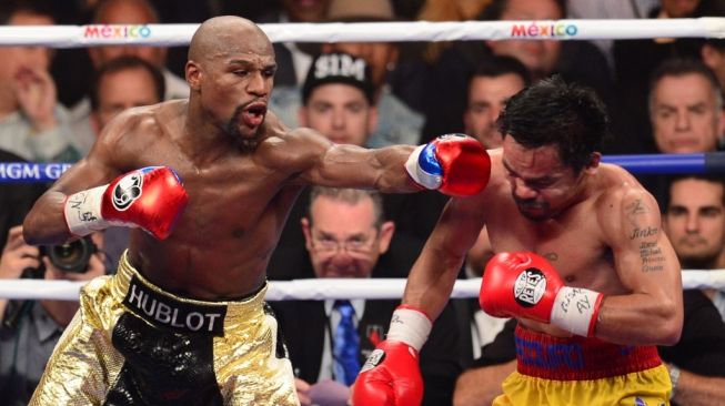 Petinju legendaris Floyd Mayweather Jr. (kiri) mendaratkan pukulan hook kiri ke wajah penantangnya, Manny Pacquiao, dalam kejuaraan tinju dunia di MGM Grand Garden Arena, Las Vegas, Amerika Serikat pada, Sabtu (2/5/2015). [AFP/Frederic J. Brown]