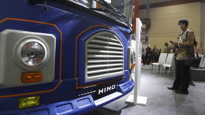 Seorang pengunjung mengamati salah satu bus yang dipamerkan di pameran otomotif GAIKINDO Indonesia International Commercial Vehicle Expo (GIICOMVEC) di Jakarta Convention Center (JCC), Jakarta, Kamis (5/3). [Suara.com/Angga Budhiyanto]