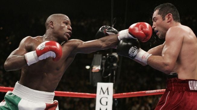 Petinju Floyd Mayweather Jr, mendaratkan jab kiri ke wajah lawannya, Oscar De La Hoya, dalam duel kejuaraan tinju dunia di MGM Grand Garden Arena, Las Vegas, AS, Sabtu (5/5/2007). [AFP/Robyn Beck]