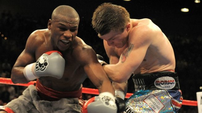 Petinju legendaris Floyd Mayweather Jr. (kiri) mendaratkan pukulan hook kiri ke wajah penantangnya, Ricky Hatton, dalam kejuaraan tinju dunia di Las Vegas, Amerika Serikat pada, Sabtu (8/12/2007). [AFP/Gabriel Bouys]