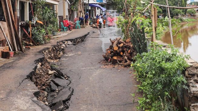 Kondisi Jalan Kesatrian X RT.12/3, Matraman, Jakarta Timur, Kamis (5/3) yang amblas. [Suara.com/Alfian Winanto]