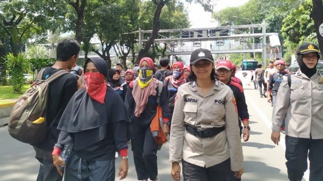 Ratusan buruh wanita saat longmarch terkait aksi tolak Omnibus Law Cilaka di kantor Kemen PPA, Jakarta. (Suara.com/M Yasir).