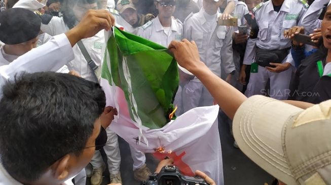 Pendemo yang berasal dari ormas FPI dll melakukan pembakaran bendera India saat berunjuk rasa di kantor Kedubes India. (Suara.com/Stephanus Aranditio).