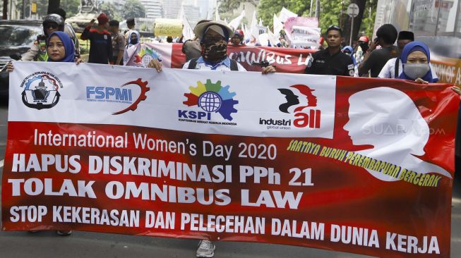 Sejumlah massa buruh perempuan yang tergabung dalam Federasi Serikat Pekerja Metal Indonesia (FSPMI) - Konfederasi Serikat Pekerja Indonesia (KSPI) melakukan longmarch menuju depan gedung Kementerian Pemberdayaan Perempuan dan Perlindungan Anak Republik Indonesia, Jalan Medan Merdeka Barat, Jakarta Pusat, Jumat (6/3). [Suara.com/Angga Budhiyanto]