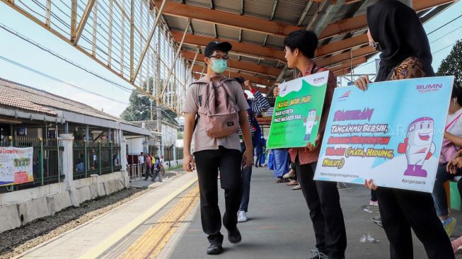 Petugas yang membawa poster cegah Corona di Stasiun Depok, Jawa Barat, Jumat (6/3). [Suara.com/Alfian Winanto]