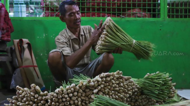 Pedagang merapikan rempah sereh yang dijualnya di Pasar Induk Kramat Jati, Jakarta Timur, Jumat (6/3). [Suara.com/Alfian Winanto]