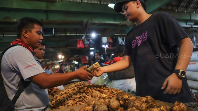 Transaksi antara pembeli dan penjual rempah temulawak di Pasar Induk Kramat Jati, Jakarta Timur, Jumat (6/3). [Suara.com/Alfian Winanto]
