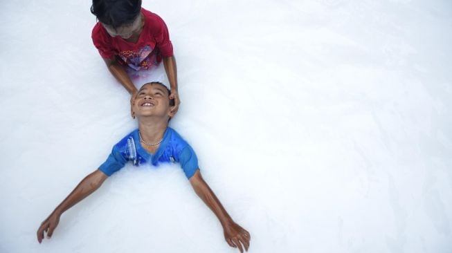 Anak-anak bermain di kolam air berwarna putih menyerupai air susu di Kecamatan Bontomarannu, Kabupaten Gowa, Sulawesi Selatan, Sabtu (7/3).  [ANTARA FOTO/Abriawan Abhe]
