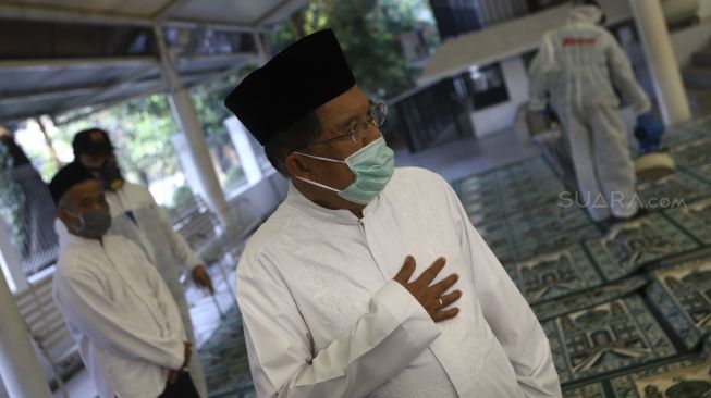 Ketua Umum Pengurus Pusat Dewan Masjid Indonesia Mohammad Jusuf Kalla meninjau penyemprotan cairan disinfektan di Masjid Nurul Hidayah, Jalan Brawijaya XII, Jakarta Selatan, Minggu (8/3). [Suara.com/Angga Budhiyanto]