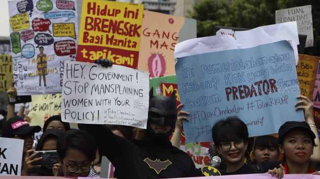 massa yang tergabung dalam Aliansi Gerakan Perempuan Anti-Kekerasan (GERAK Perempuan) menggunakan kostum Batman saat melakukan aksi unjuk rasa di depan kantor Bawaslu, Jakarta, Minggu (8/3). [Suara.com/Angga Budhiyanto]