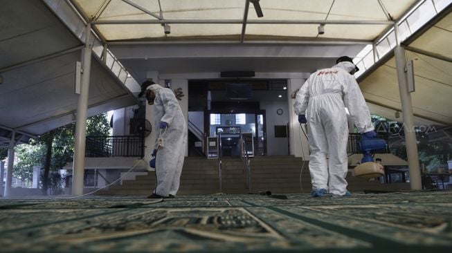 Petugas menyemprotkan cairan disinfektan di Masjid Nurul Hidayah, Jalan Brawijaya XII, Jakarta Selatan, Minggu (8/3). [Suara.com/Angga Budhiyanto]