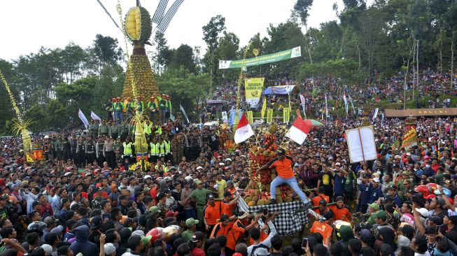 Pengunjung berebut buah durian saat pesta durian atau Kenduren di Lapangan Wonosalam, Kabupaten Jombang, Jawa Timur, Minggu (8/3). [ANTARA FOTO/Syaiful Arif]