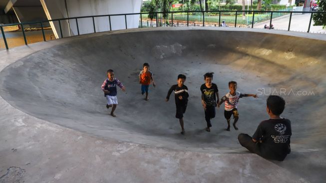 Bocah bermain di area Skate park Fly Over Slipi, Jakarta Pusat, Senin  (9/3). [Suara.com/Alfian Winanto]