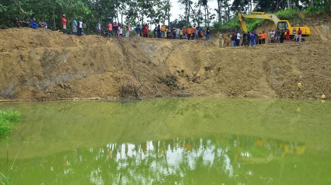 Warga menyaksikan tempat galian C lokasi tenggelamnya santri dan seorang Kyai di Dusun Sobotuwo, Kronggen, Brati, Grobogan, Jawa tengah, Senin (9/3). [ANTARA FOTO/Yusuf Nugroho]