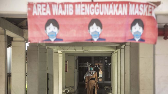 Warga berjalan menggunakan masker di RSPI Sulianti Saroso, Jakarta, Selasa (10/3).  [ANTARA FOTO/Aprillio Akbar]