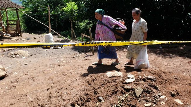 Dua warga berjalan menuju tempat pengungsian di lokasi bencana tanah bergerak Dusun Kranjang Lor, Sidosari, Salaman, Magelang, Jawa Tengah Selasa (10/3). [ANTARA FOTO/Anis Efizudin]