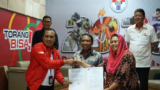 Menpora Zainudin Amali (tengah) dan Ketua Umum FPTI Yenny Wahid (kedua dari kanan) dalam MoU pencairan dana Pelatnas dan Olimpiade 2020 di Gedung Kemenpora, Senayan, Jakarta, Selasa (10/3/2020). [Suara.com/Arief Apriadi]