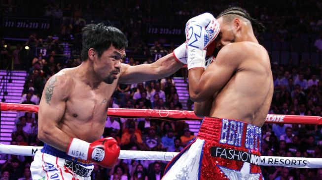 Petinju Filipina, Manny Pacquiao, melayangkan hook kiri ke wajah lawannya asal AS, Keith Thurman, dalam duel kejuaraan tinju dunia di MGM Grand, Las Vegas, Sabtu (20/7/2019). [AFP/John Gurzinski]