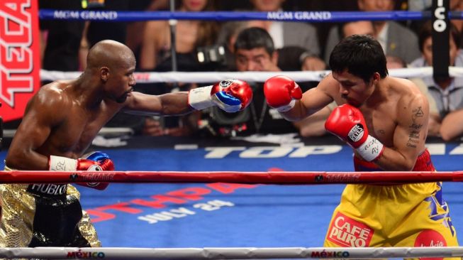 Petinju legendaris Floyd Mayweather Jr. (kiri) berduel dengan Manny Pacquiao dalam kejuaraan tinju dunia di MGM Grand Garden Arena, Las Vegas, Amerika Serikat pada, Sabtu (2/5/2015). [AFP/Frederic J. Brown]