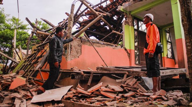 Warga melihat bangunan ambruk akibat gempa bumi di kecamatan Kabandungan, Sukabumi, Jawa Barat, Rabu (11/3). [ANTARA FOTO/Budiyanto]
