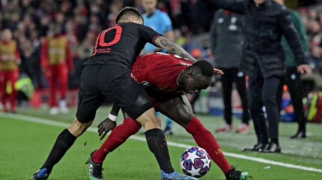 Striker Atletico Madrid Angel Correa (kiri) bersaing dengan striker Liverpool Sadio Mane selama pertandingan Liga Champions babak 16 besar antara Liverpool melawan Atletico Madrid di Anfield, Liverpool, Inggris, Kamis (12/3) dini hari WIB. [JAVIER SORIANO / AFP]