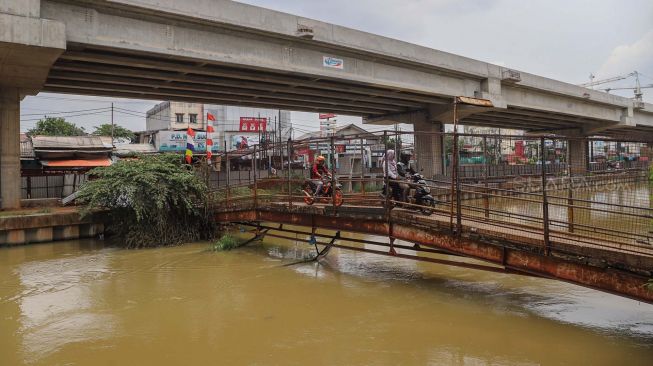 JPO (Jembatan Penyeberangan Orang) dilewati motor di Jl. KH. Noer Ali, Kalimalang, Bekasi, Kamis (12/3). [Suara.com/Alfian Winanto]