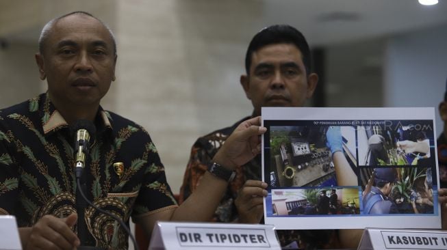 Direktur Tindak Pidana Tertentu Bareskrim Brigjen Pol Mohamad Agung Budijono (kiri) menunjukkan foto TKP penemuan barang bukti zat radioaktif saat Penyidikan Tindak Pidana di Bidang Ketenaganukliran di Gedung Bareskrim Polri Jakarta, Jumat (13/3). [Suara.com/Angga Budhiyanto]