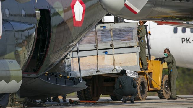 Personel TNI Angkatan Udara dengan menggunakan alat berat menurunkan bahan material yang akan digunakan untuk pembangunan rumah sakit khusus Corona (COVID-19) dari pesawat Hercules C-130 di Bandara Hang Nadim Batam, Kepulauan Riau, Kamis (12/3). [ANTARA FOTO/M N Kanwa]