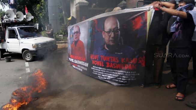 Massa yang tergabung dalam aliansi corong rakyat melakukan aksi bakar ban di Kejaksaan Agung, Jakarta, Jumat (13/3). [Suara.com/Oke Atmaja]